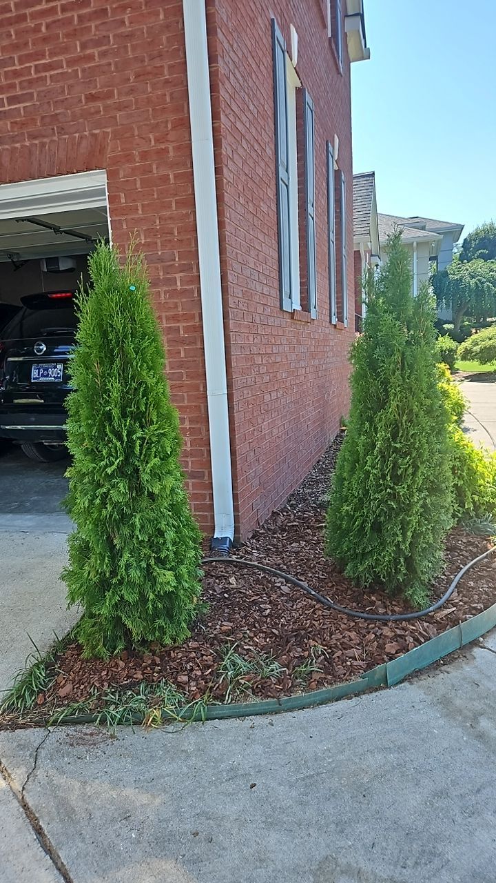 A car is parked in a garage next to a brick building with everu