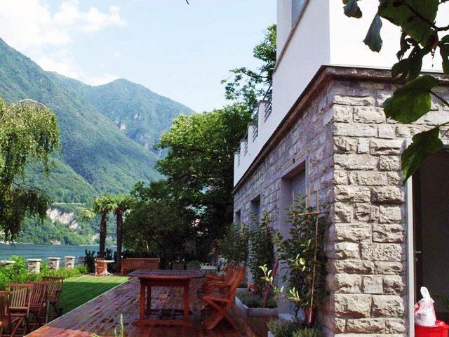 villa con giardino e tavoli in legno