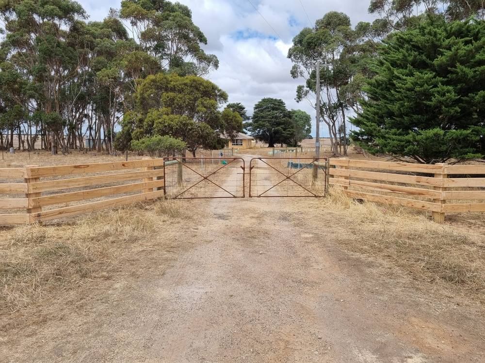 A Dirt Road With A Wooden Fence And A Gate — Ettles Rural Fencing in Alfredton, VIC