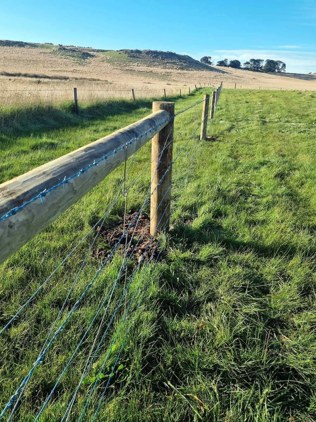 A Wooden Fence Is Surrounding A Muddy Field — Ettles Rural Fencing in Alfredton, VIC