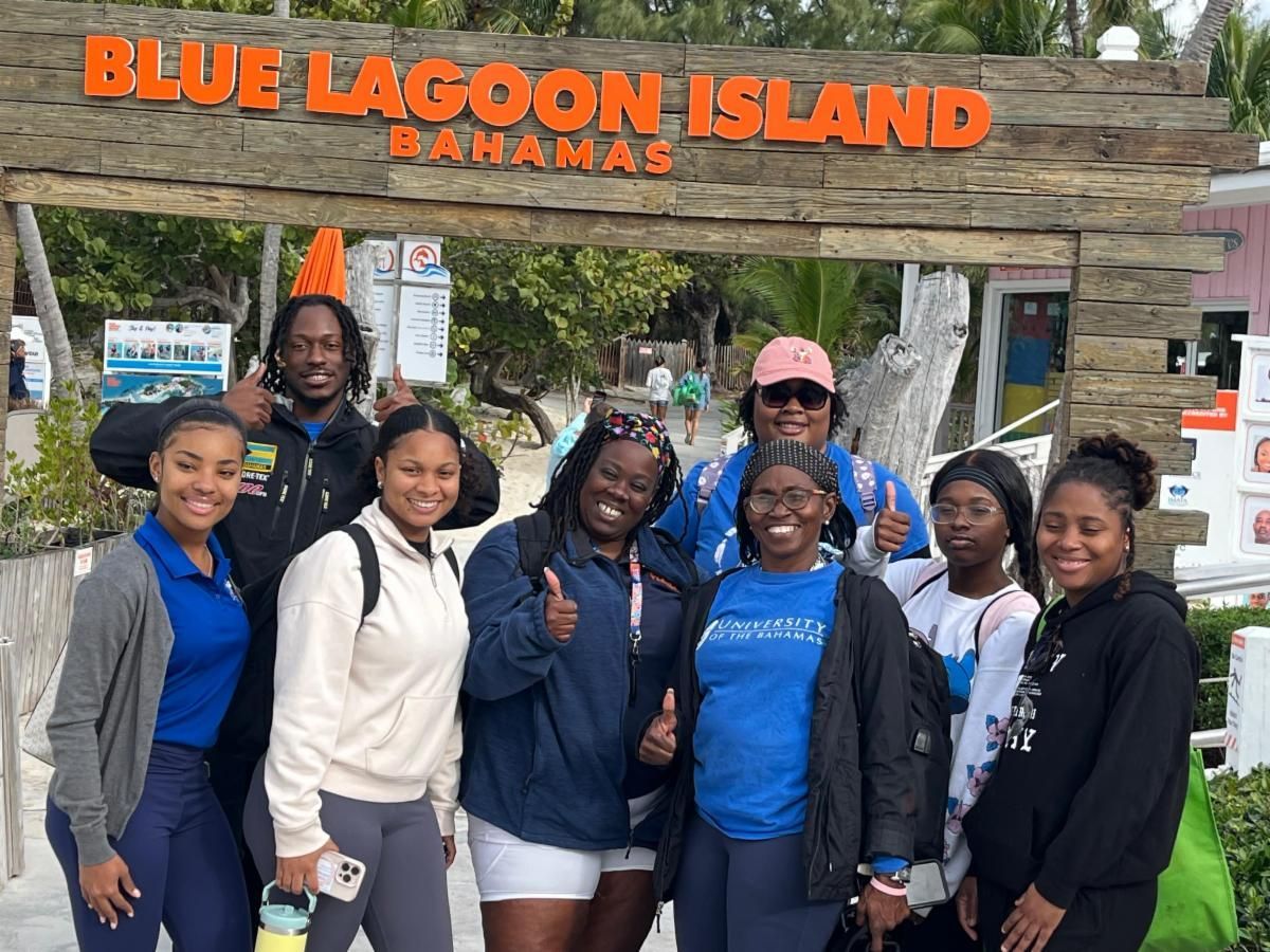 Group of people posing in front of a 