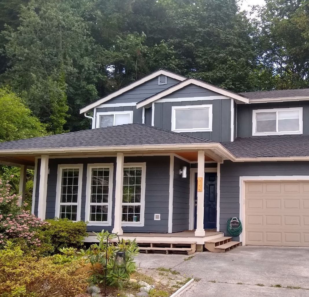 A gray house with a porch and a garage