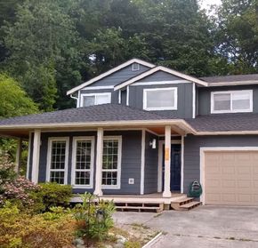 A gray house with a porch and a garage