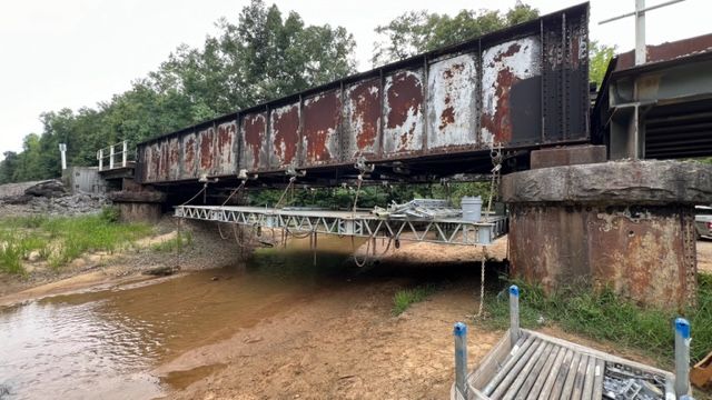 A bridge over a river with graffiti on it.