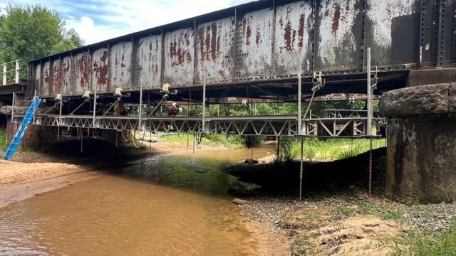 A bridge over a river with graffiti on it.