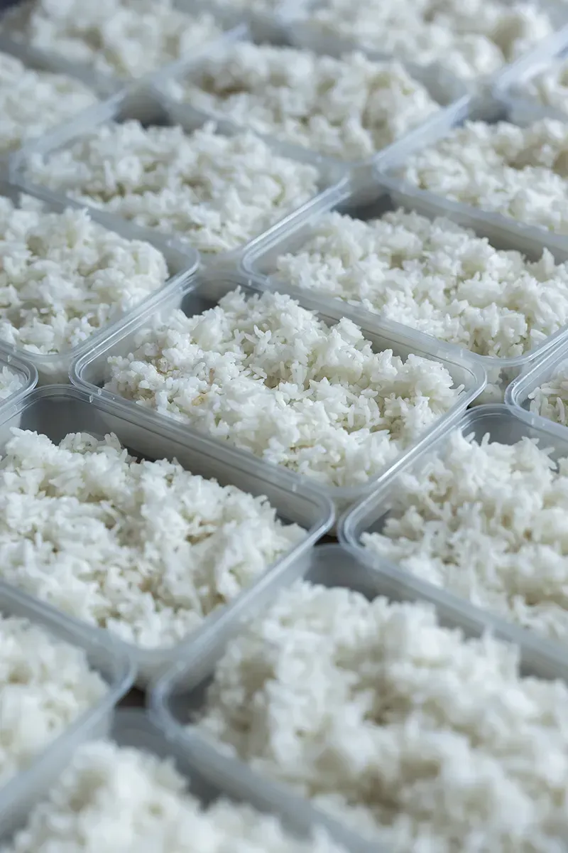 Récipients remplis de riz blanc cuit, préparé pour les repas.