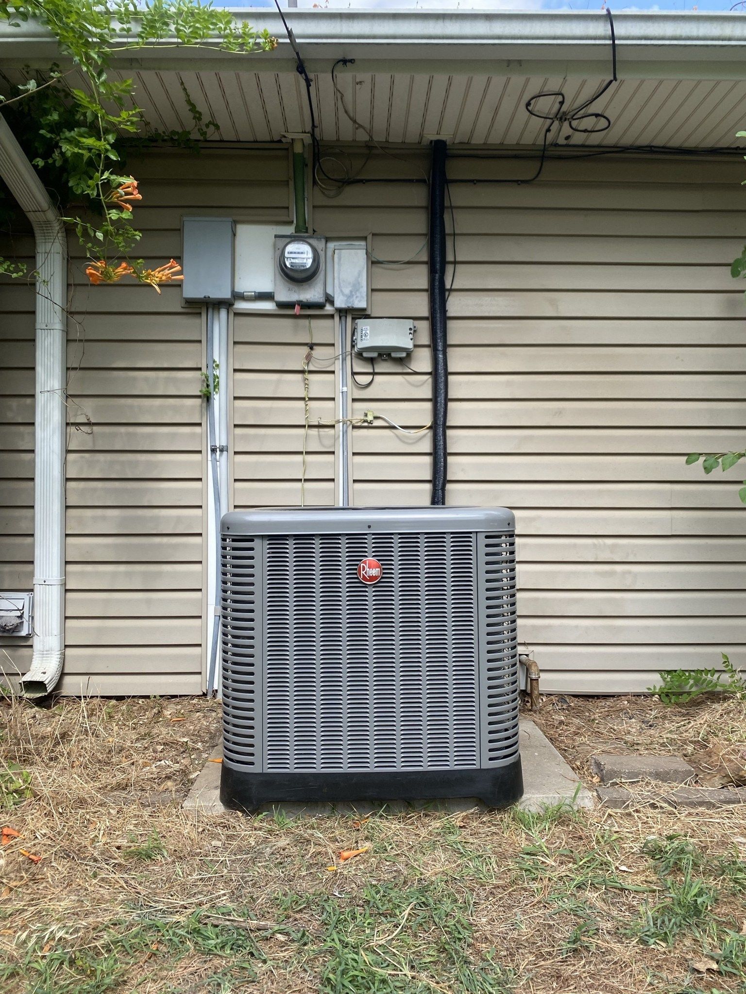 An air conditioner is sitting on the side of a house.