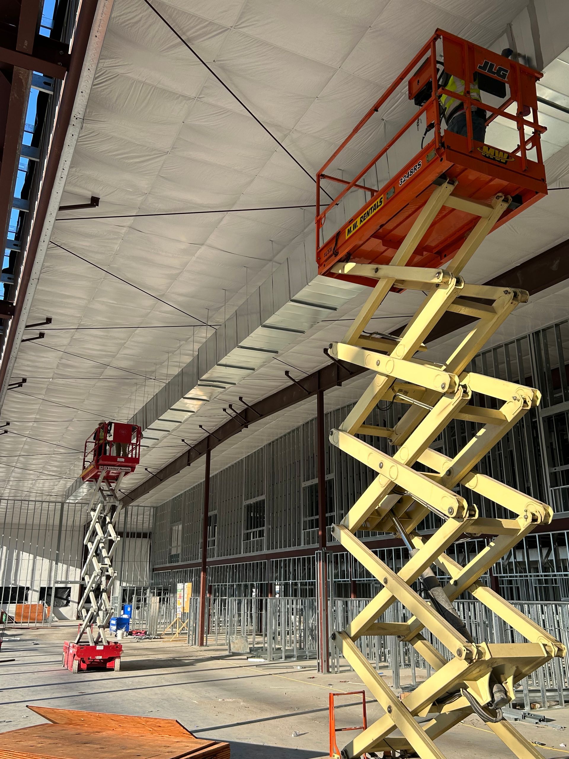 Gray metal building with HVAC units and a ladder.