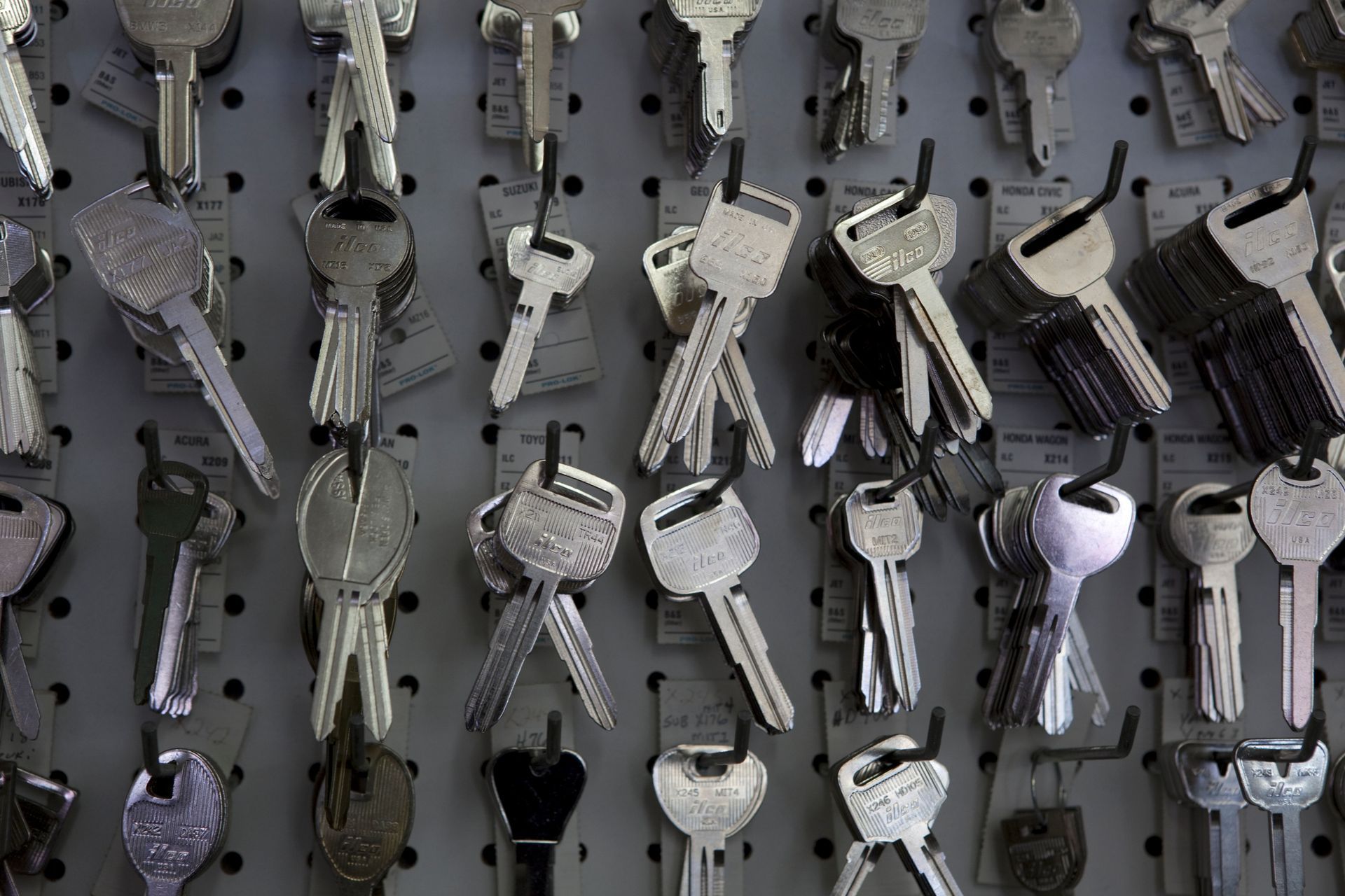 A bunch of keys are hanging on a wall.