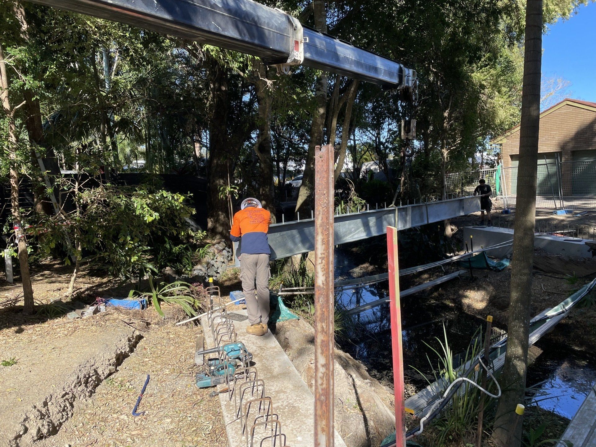 A man is standing on a bridge over a body of water.