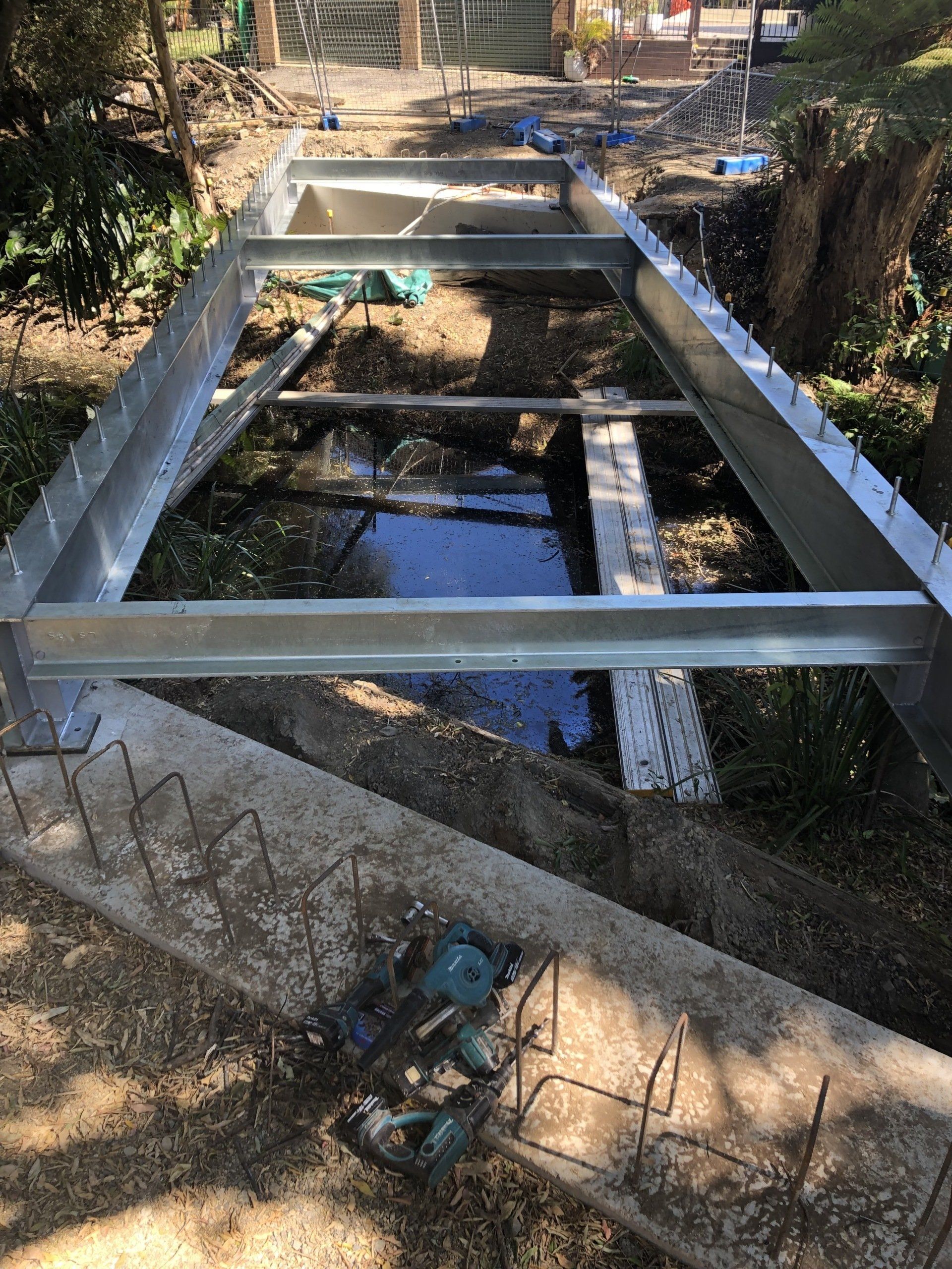 A metal structure is being built over a body of water.