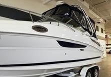 A white cabin cruiser boat on a trailer inside a showroom.