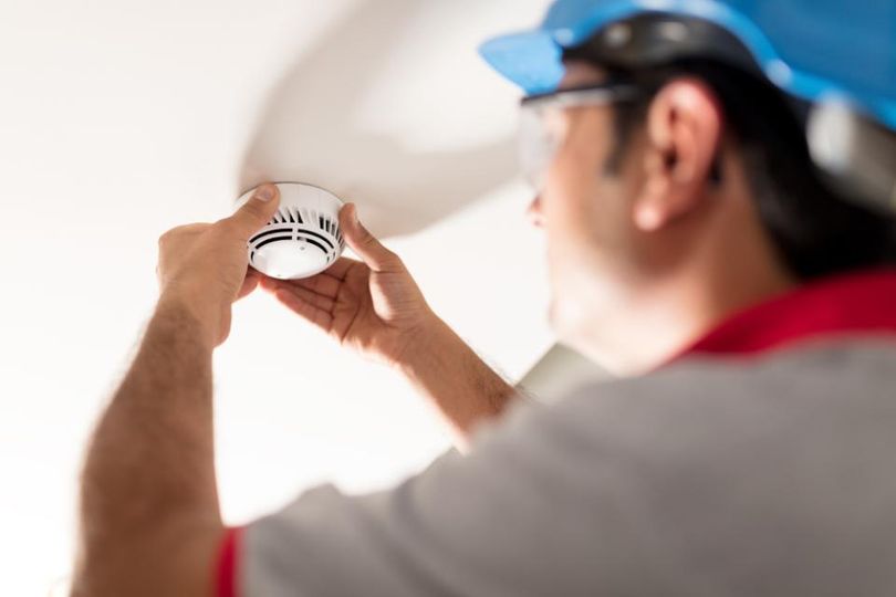 man installing smoke detector