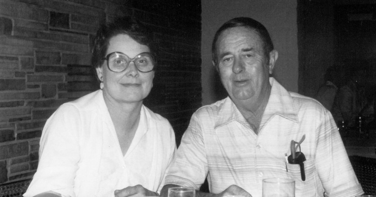 a black and white photo of Ed and Mary Lou Rhodes sitting at a table