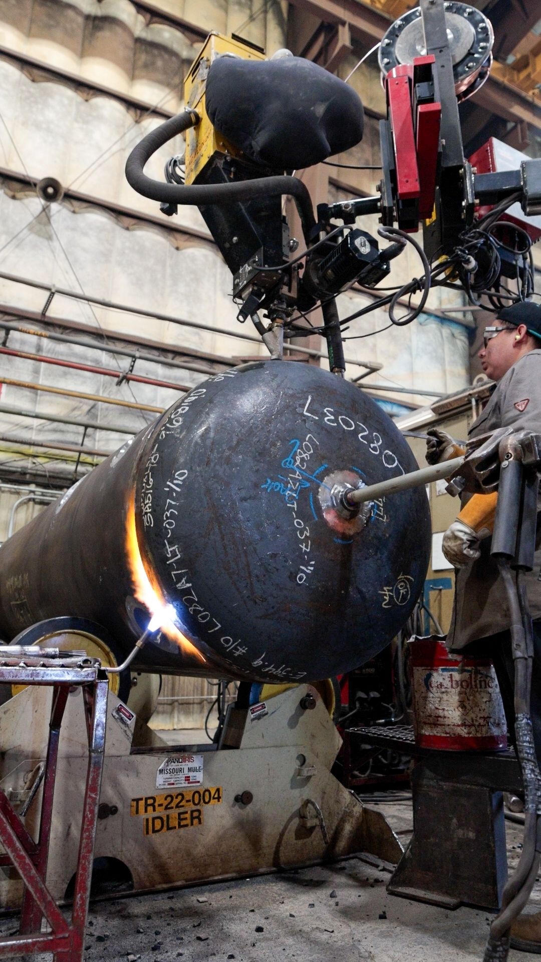 a Pesco employee wearing a welding mask is welding a pipe