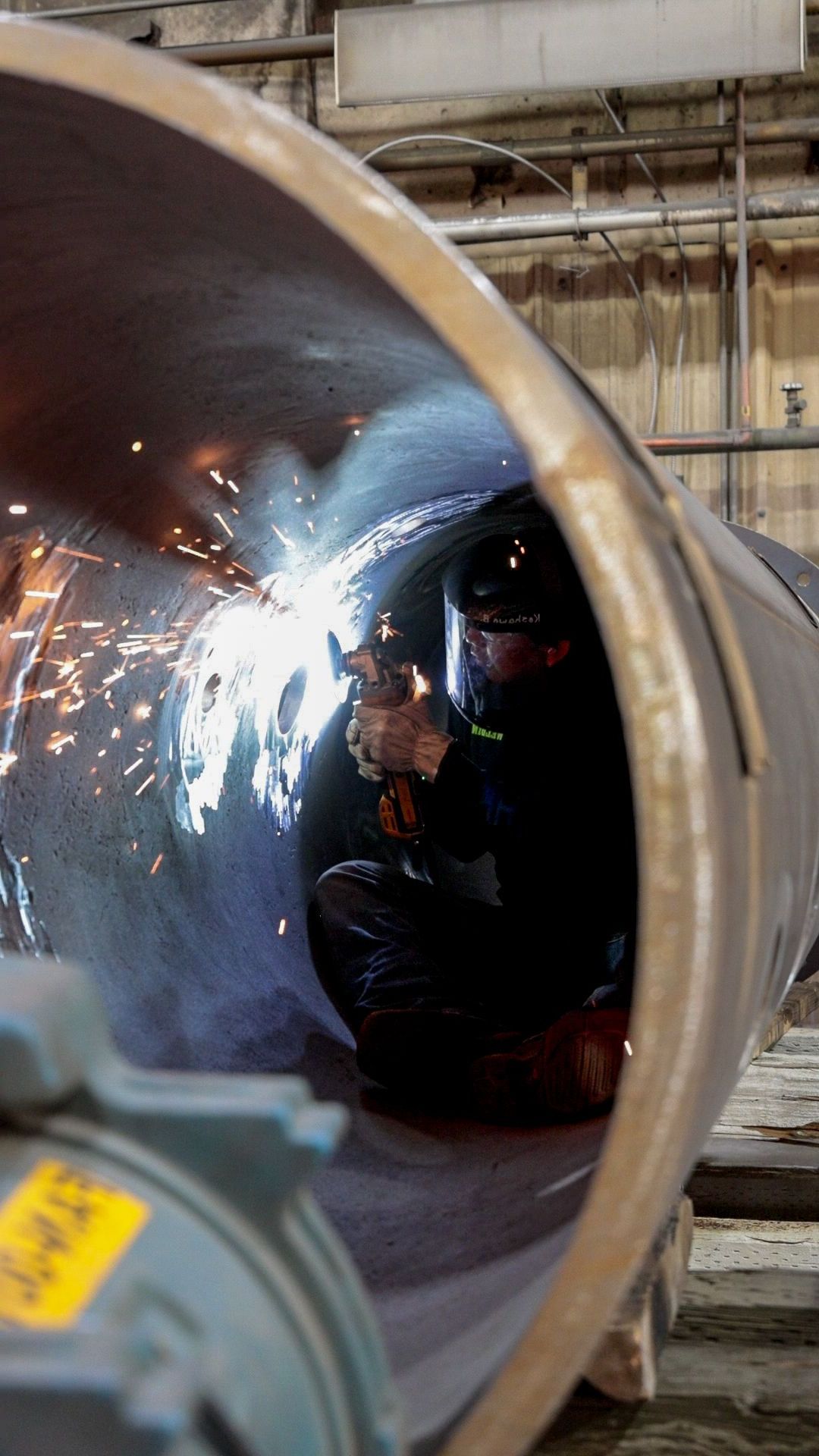 a bunch of pipes in a factory with one that says ' stainless steel ' on it