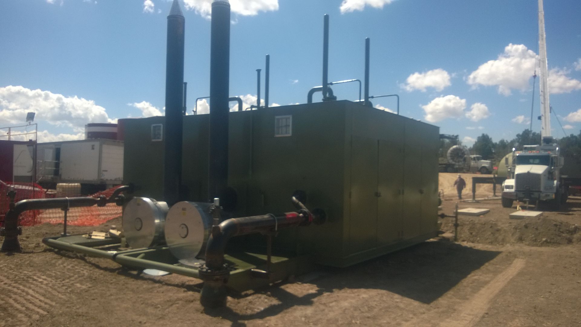 A truck is parked in front of a large green tank