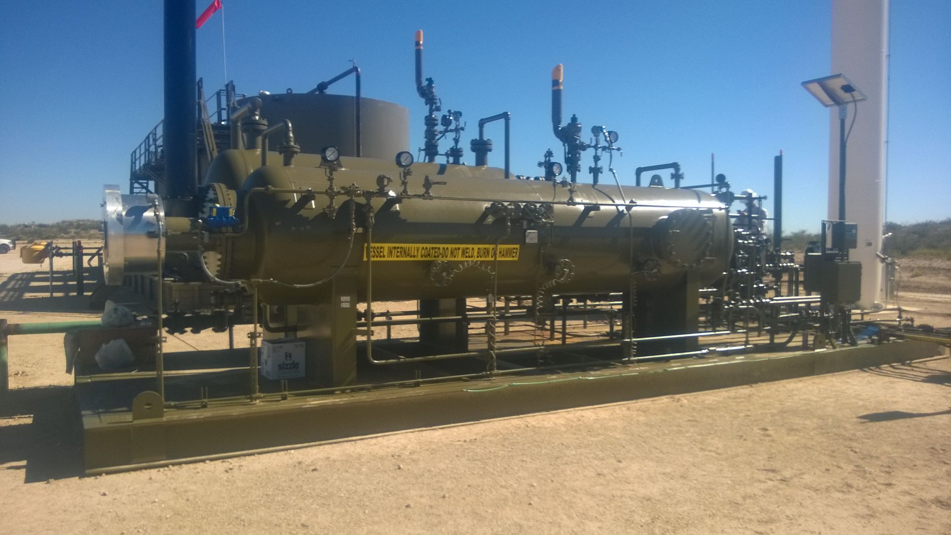 A large tank with a yellow warning sign on it