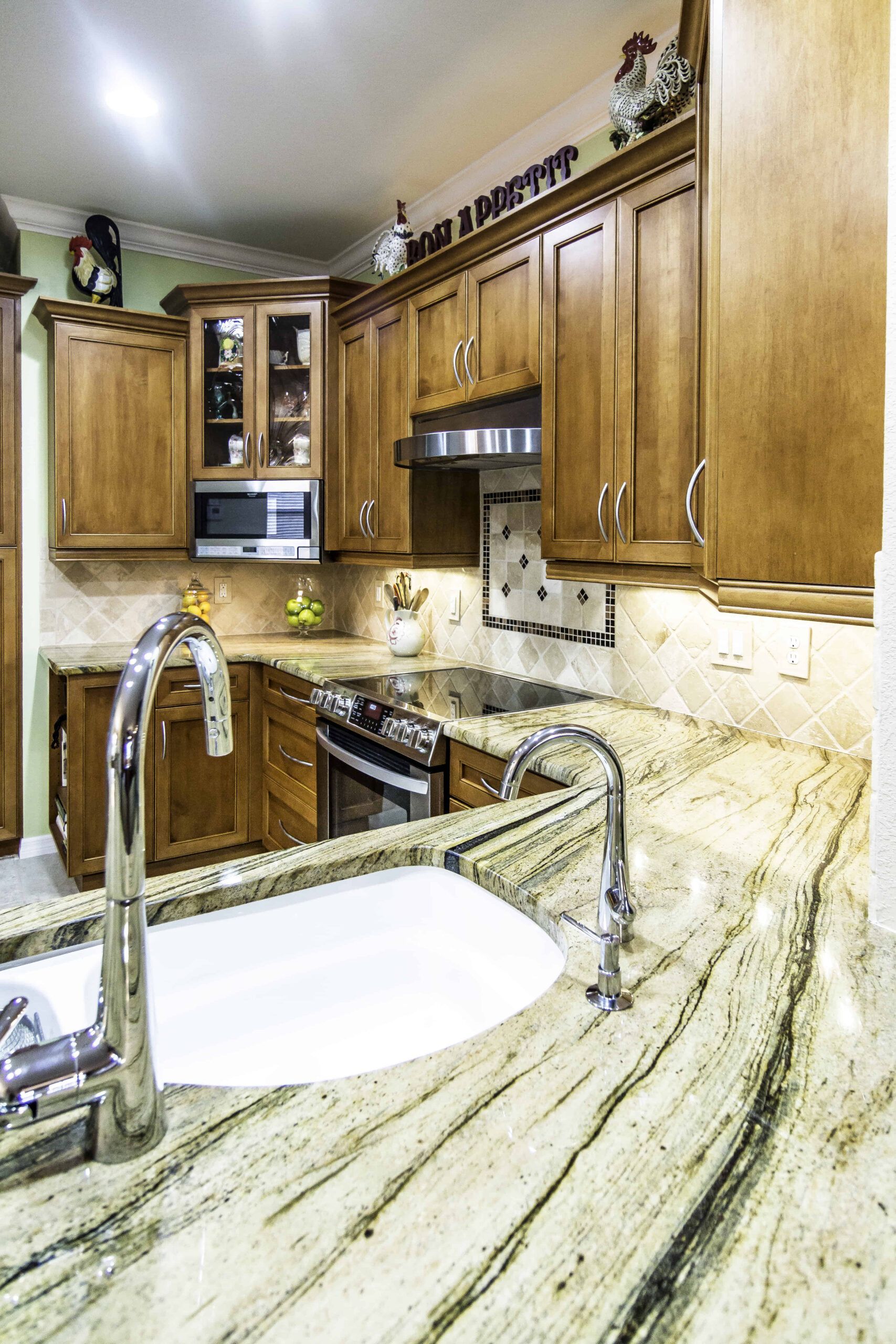 Modern kitchen with marble island, wood cabinets, and stainless steel appliances