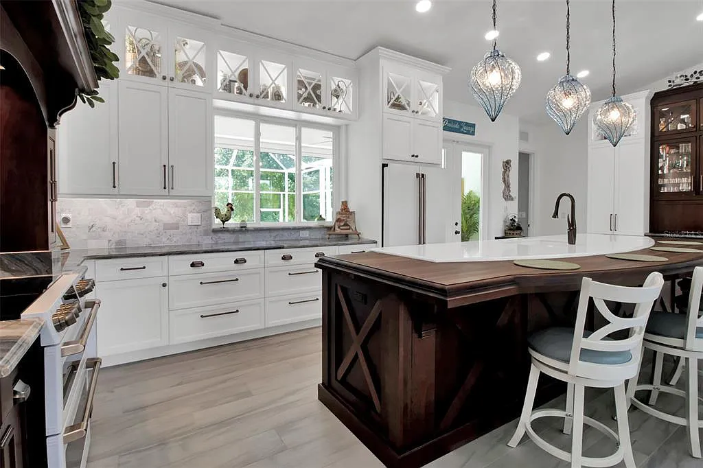 Kitchen remodeling in Rotonda West, FL, bright white kitchen with island, pendant lights, and large windows