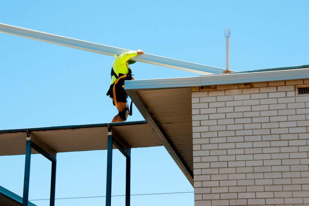 A Man is Working on the Roof of a Building — TM Built Construction In Thornton, NSW