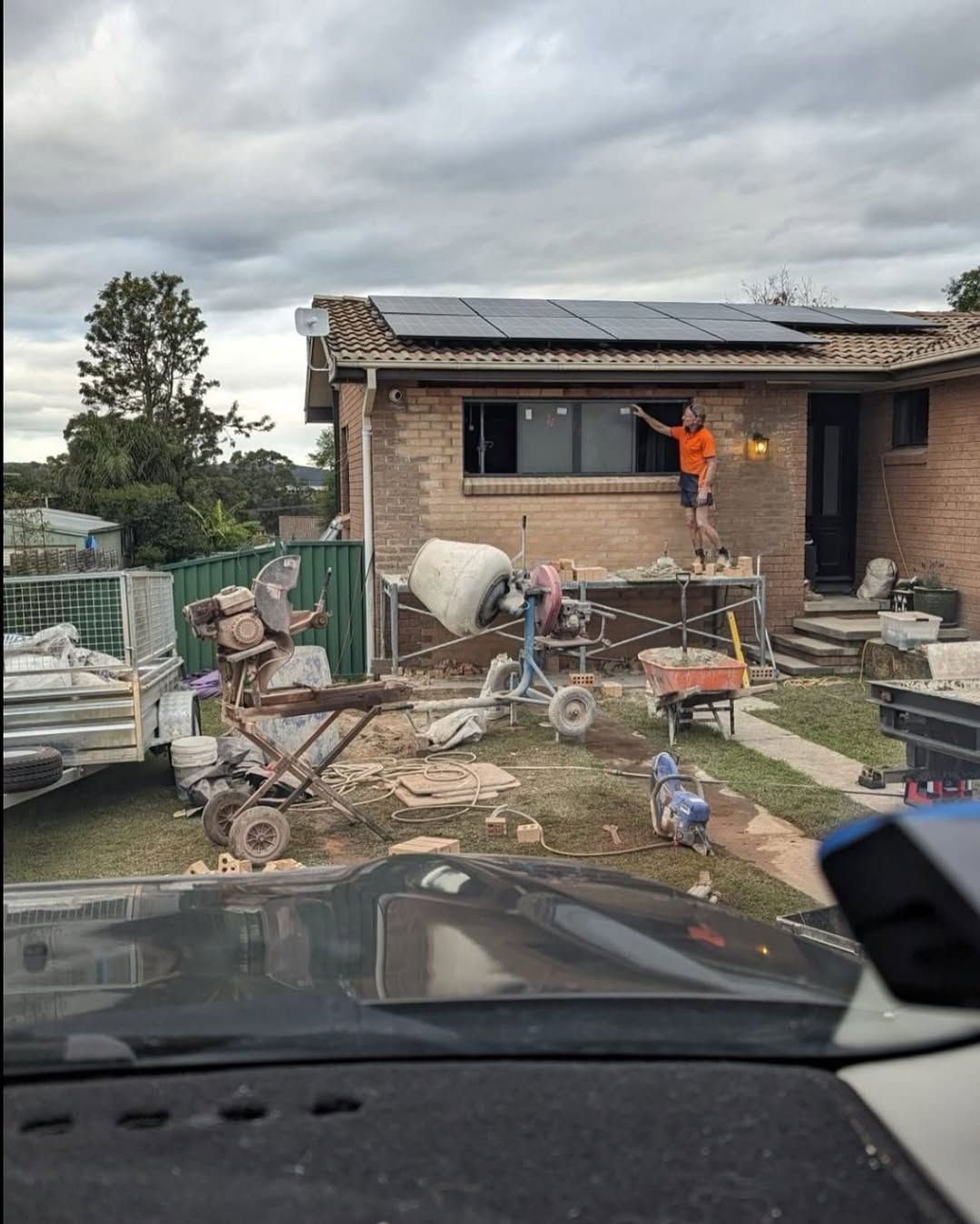 A Man Is Working On The Roof Of A Building — TM Built Construction In Lochinvar, NSW