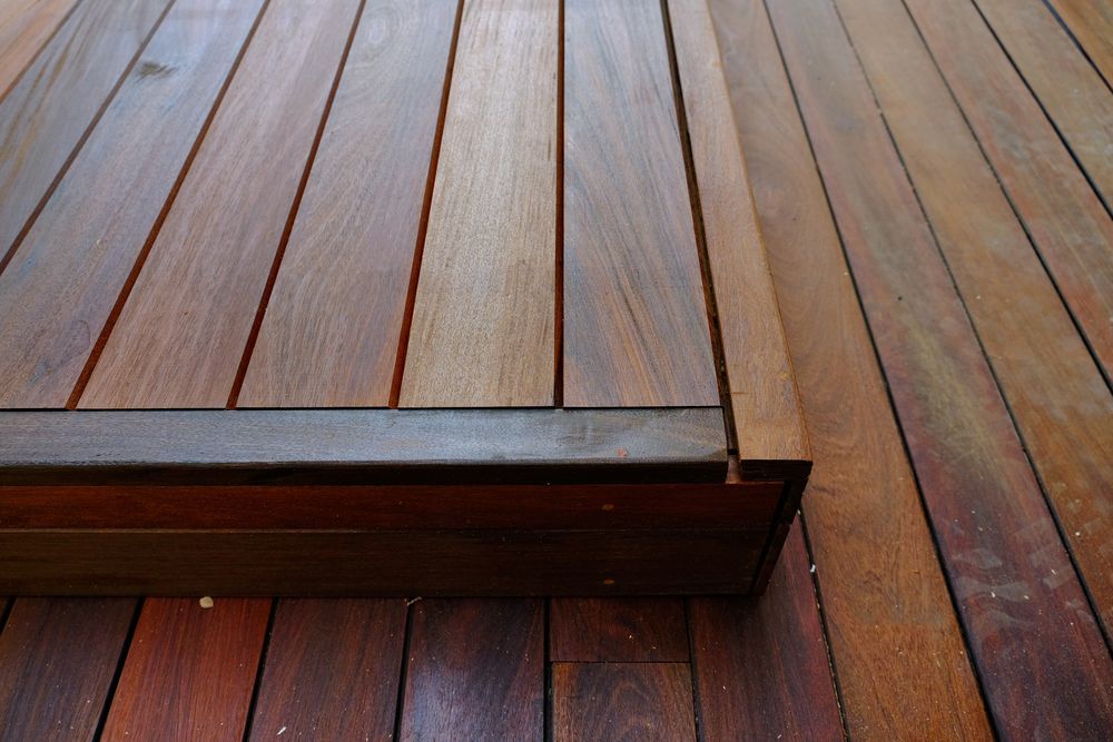 A Close Up of a Wooden Deck With a Metal Railing — TM Built Construction In Rutherford, NSW
