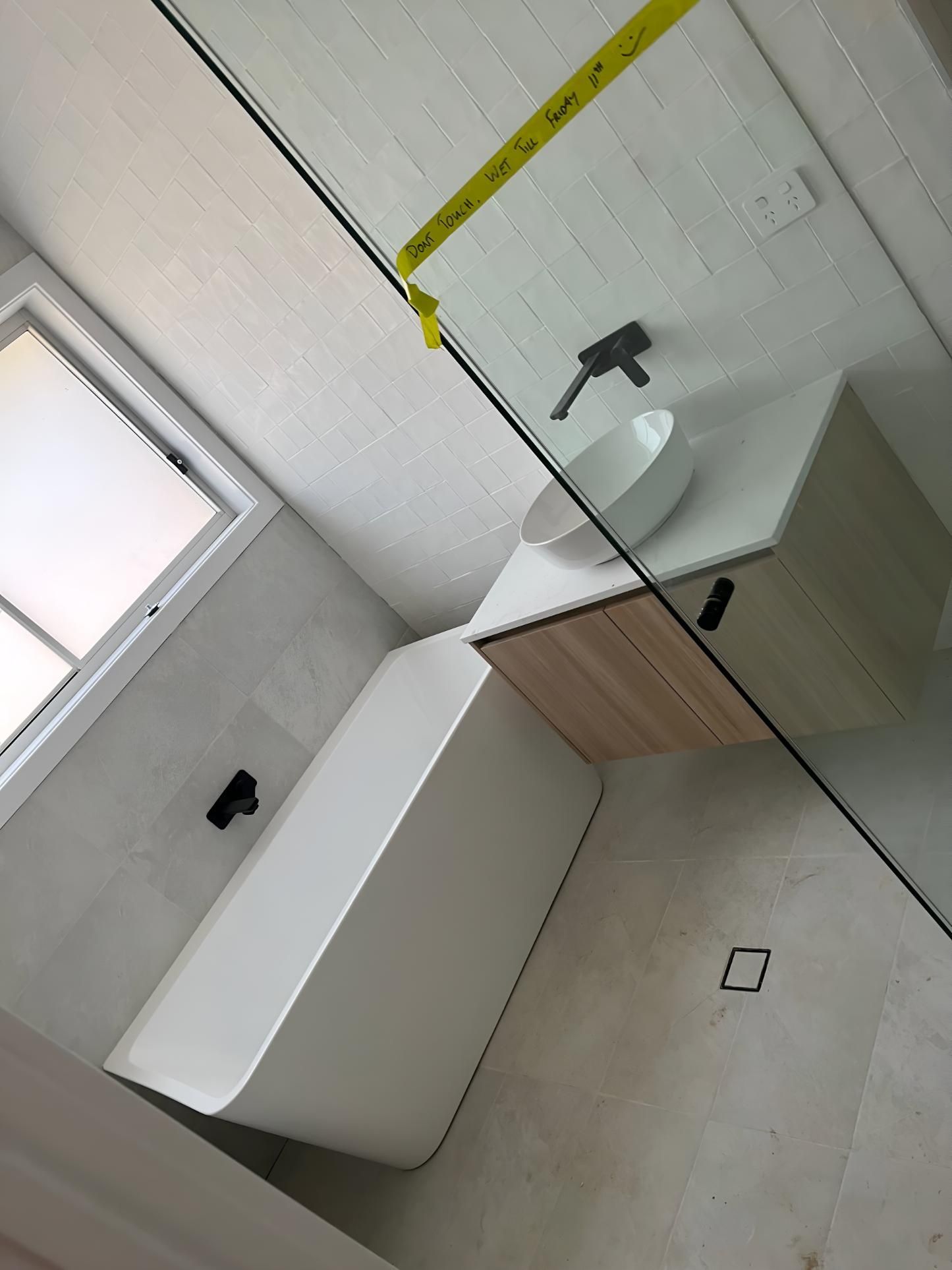 Bathroom With a Bathtub, Sink, and Window — TM Built Construction In Maitland, NSW