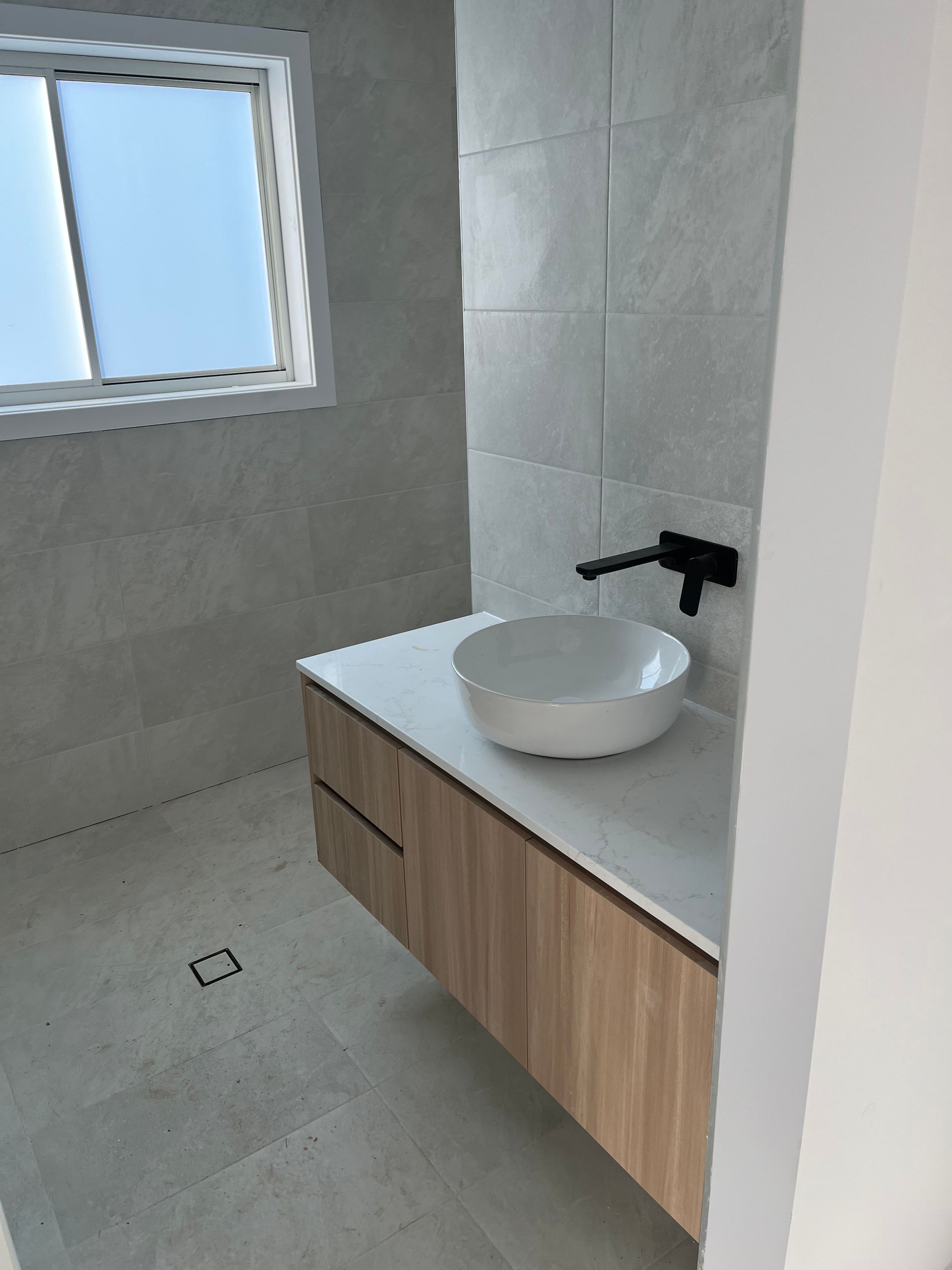 A bathroom with a sink and a window — TM Built Construction In Lochinvar, NSW