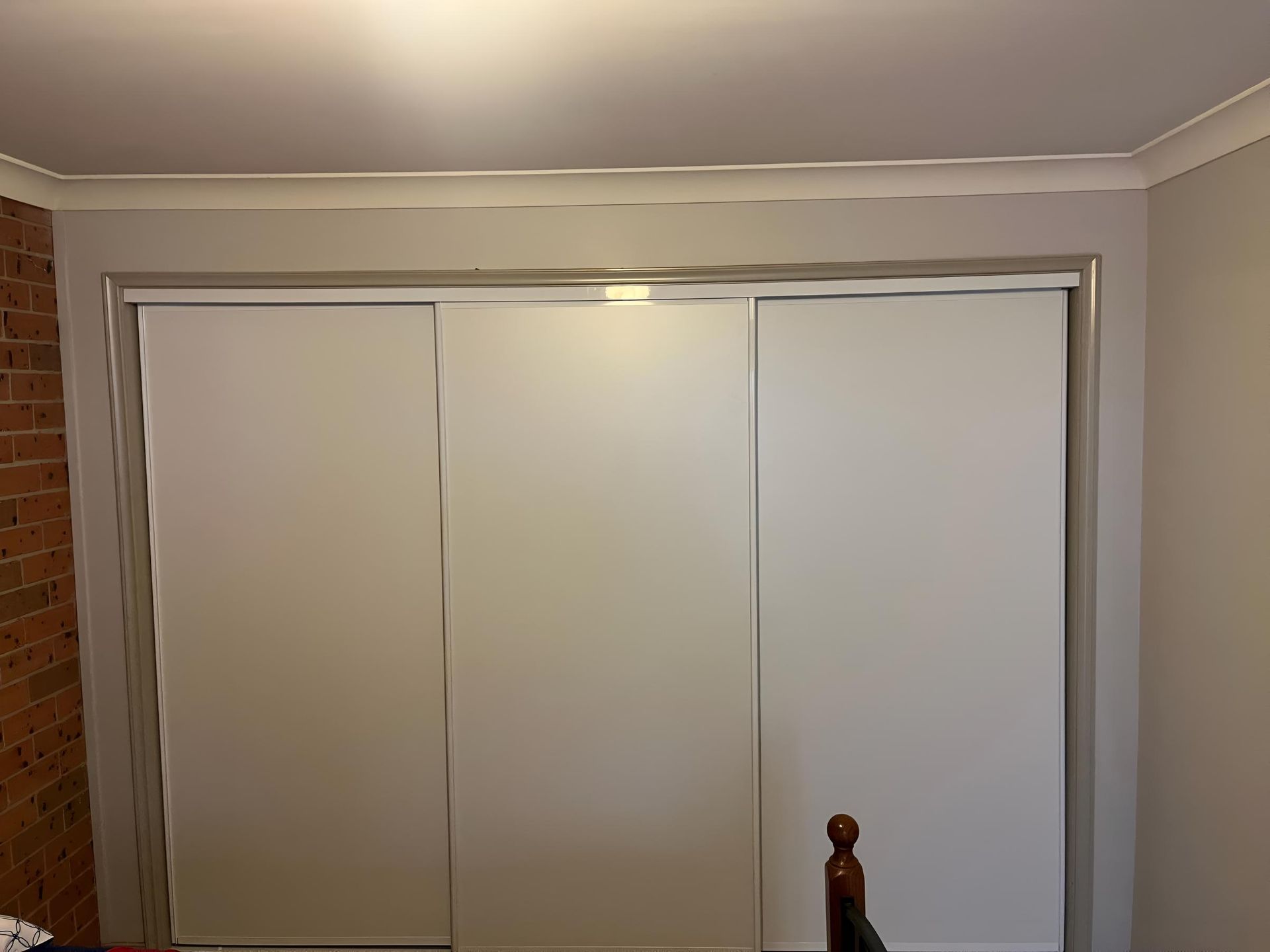Bedroom With White Sliding Doors and a Brick Wall — TM Built Construction In Maitland, NSW