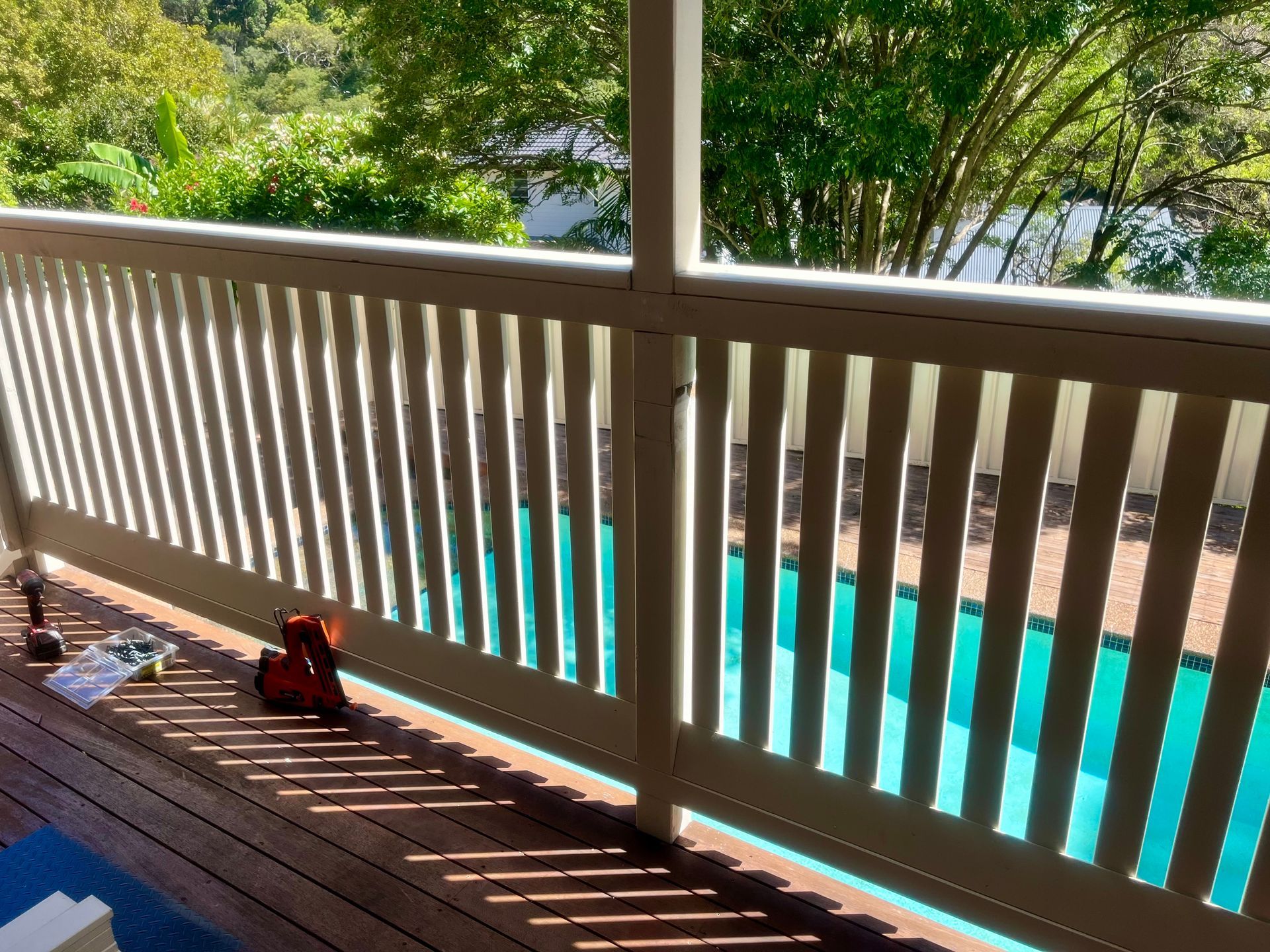 A white railing on a deck overlooking a pool — TM Built Construction In Lochinvar, NSW