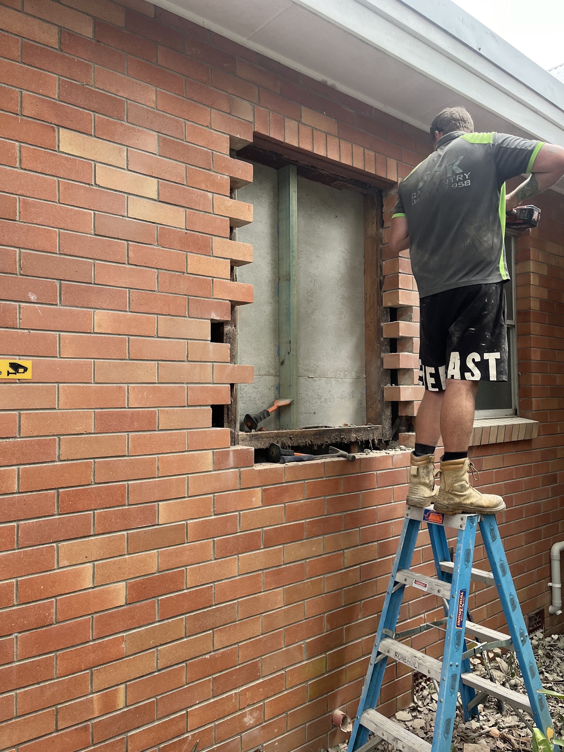 A Man is Fixing a Pipe With a Wrench and a Screwdriver — TM Built Construction In Lochinvar, NSW
