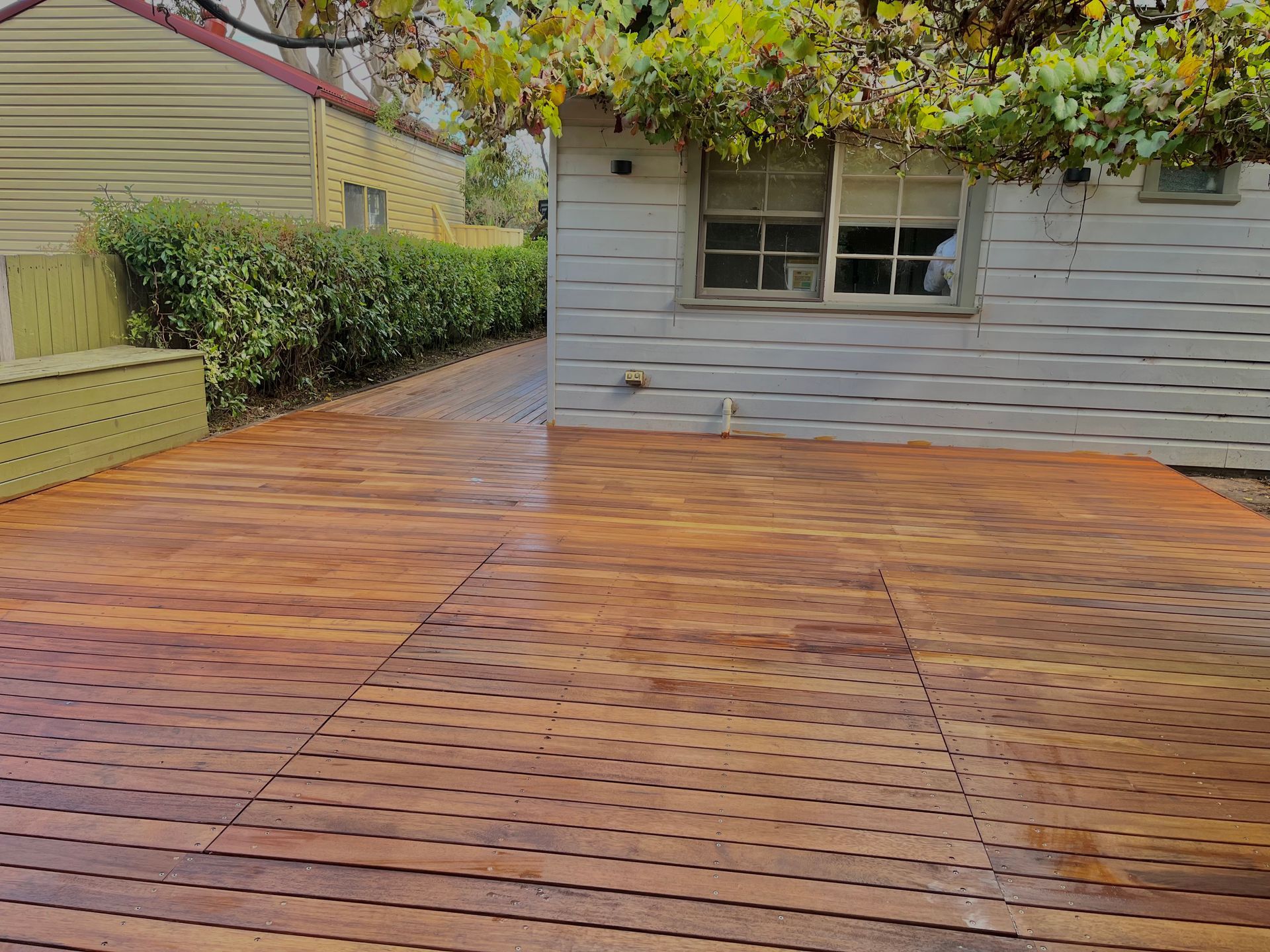 A wooden deck in front of a house with a window — TM Built Construction In Lochinvar, NSW