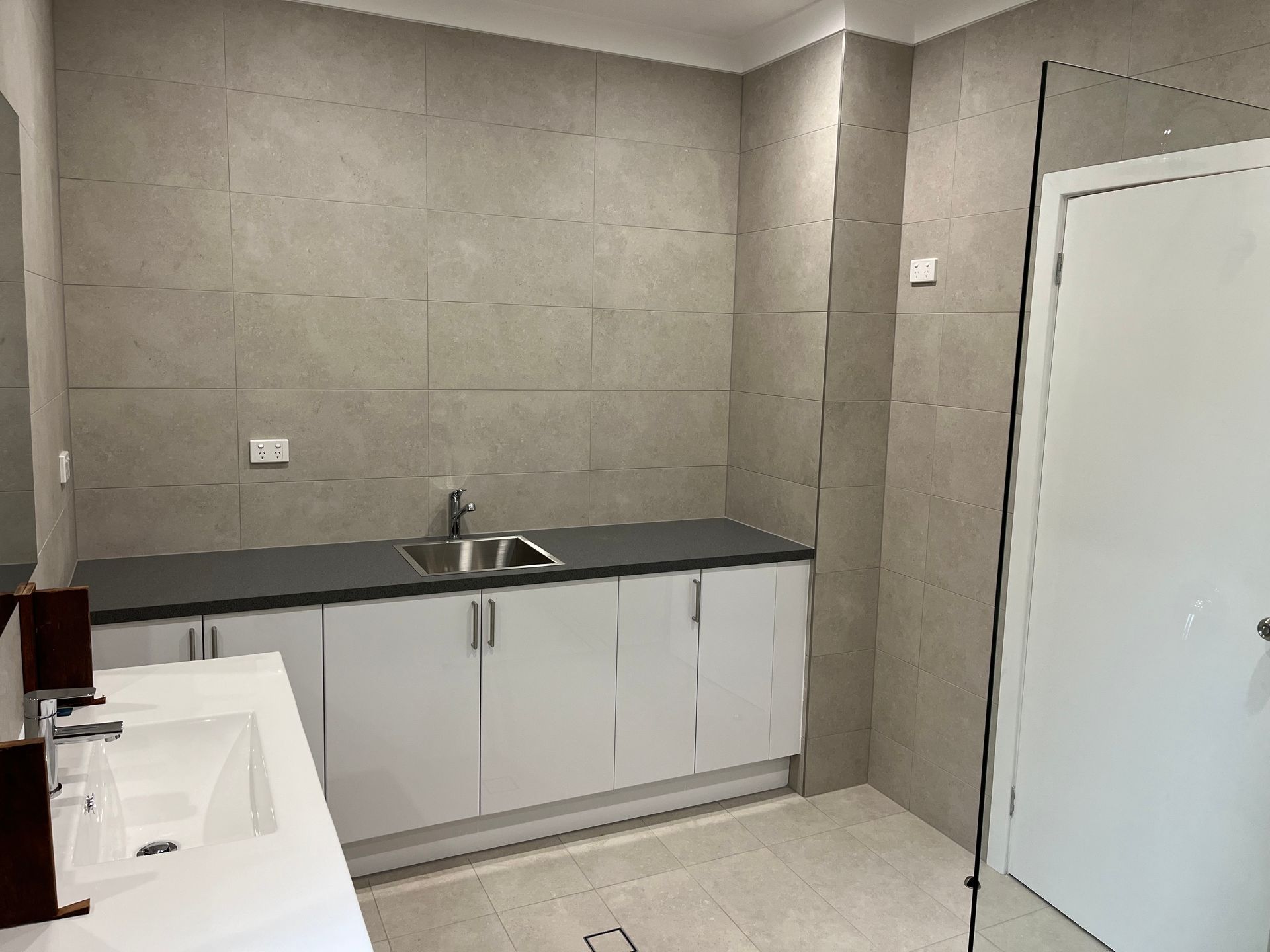 A bathroom with a sink , cabinets , and a walk in shower — TM Built Construction In Lochinvar, NSW