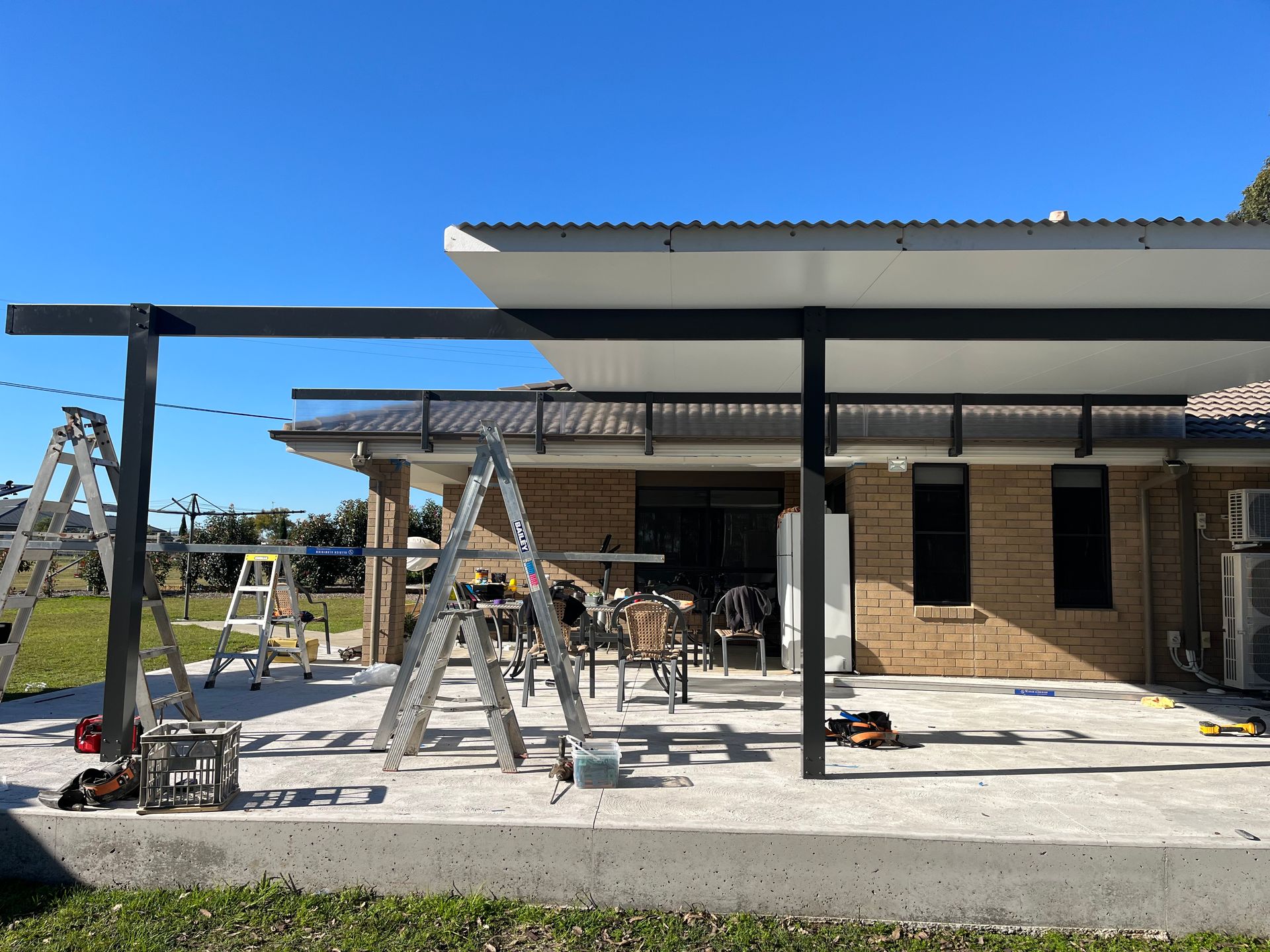 A house with a covered patio and a ladder in front of it — TM Built Construction In Lochinvar, NSW