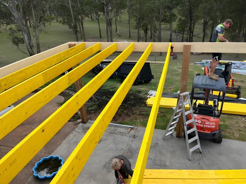 Man is Working on a Wooden Deck With Yellow Beams — TM Built Construction In Branxton, NSW