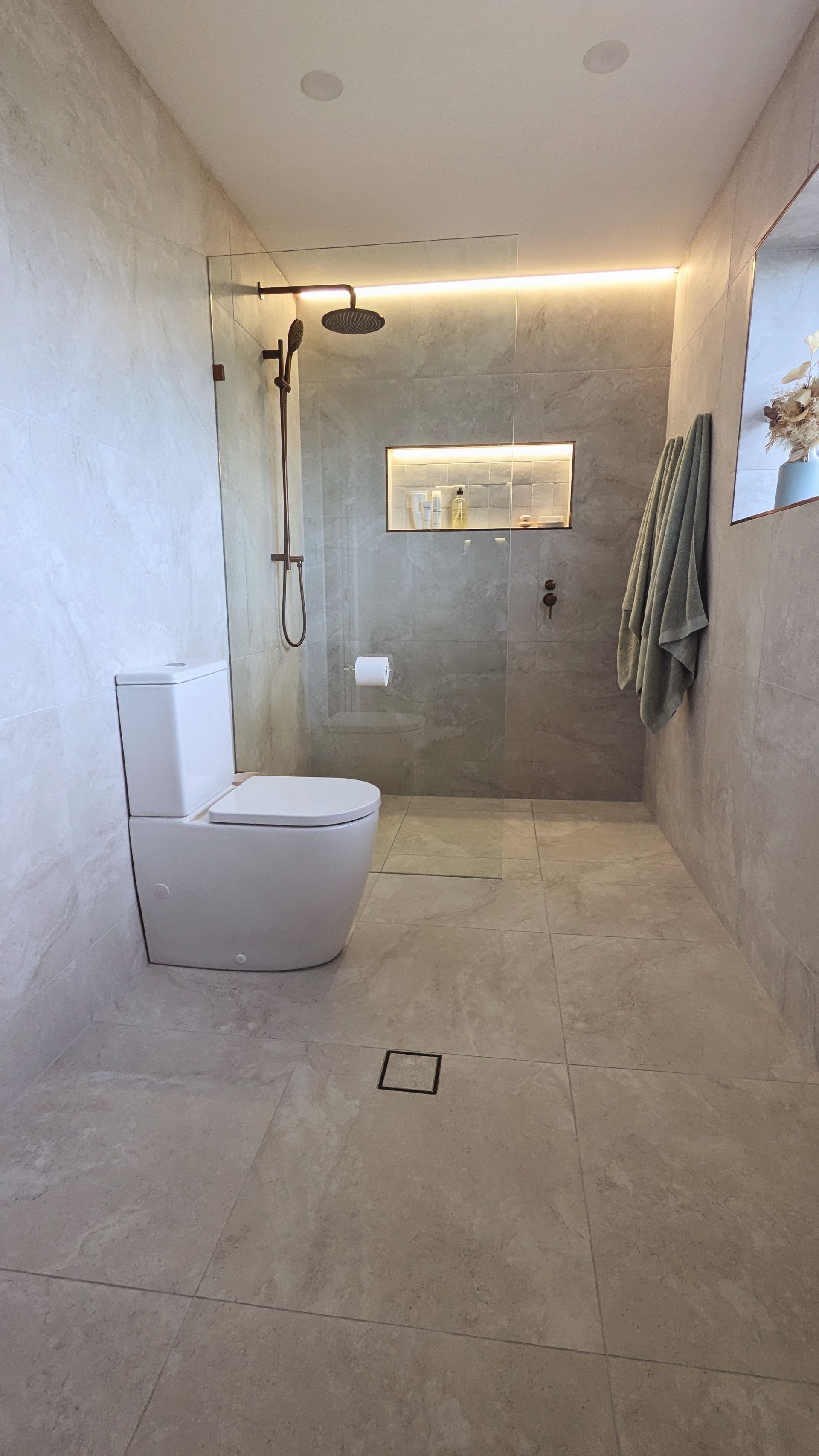 A Man is Fixing a Bathtub Faucet With a Wrench — TM Built Construction In Lochinvar, NSW