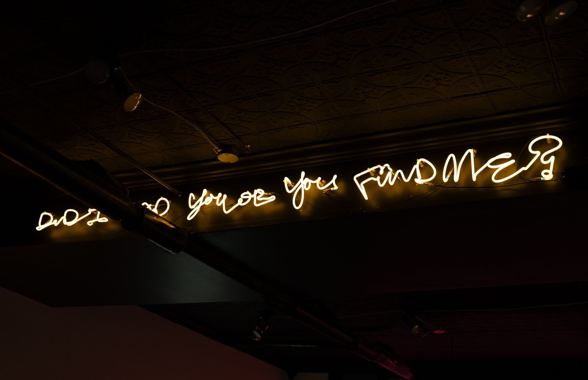 Yellow neon sign on ceiling: 