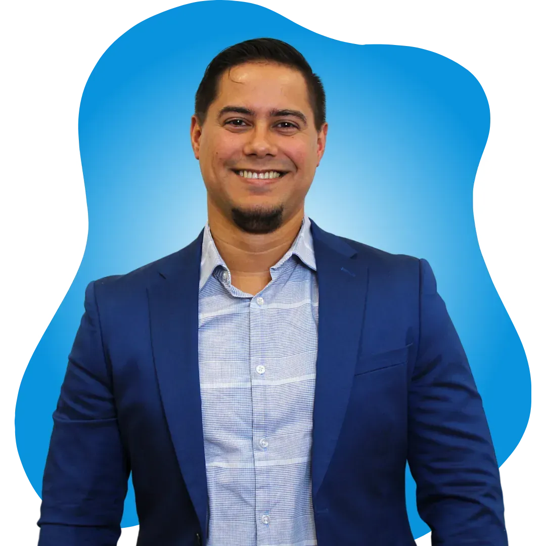 A man in a blue suit is smiling in front of a blue background