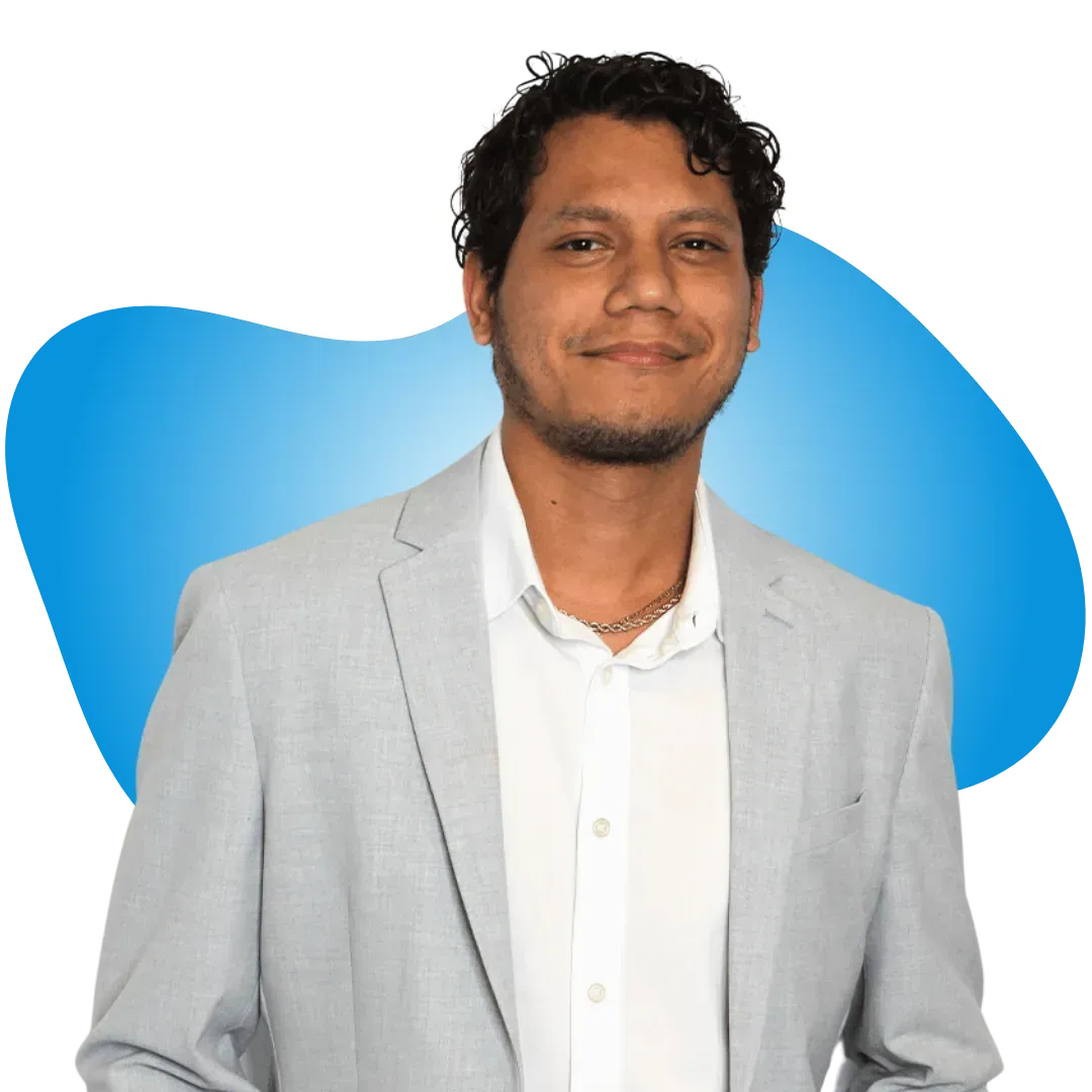 A man in a suit and white shirt stands in front of a blue background