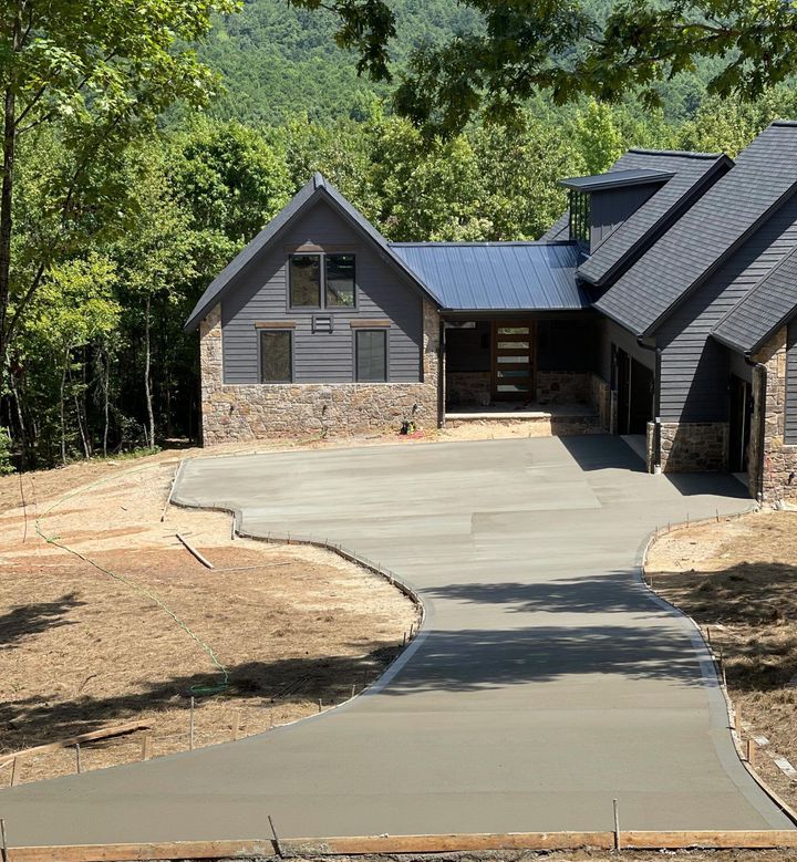 A large house with a concrete driveway leading to it