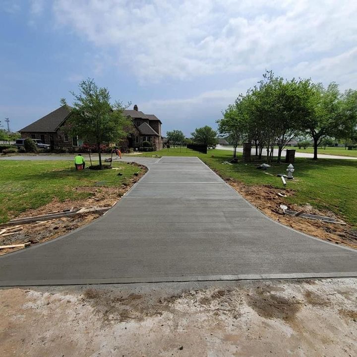 A concrete driveway is being built in front of a house.