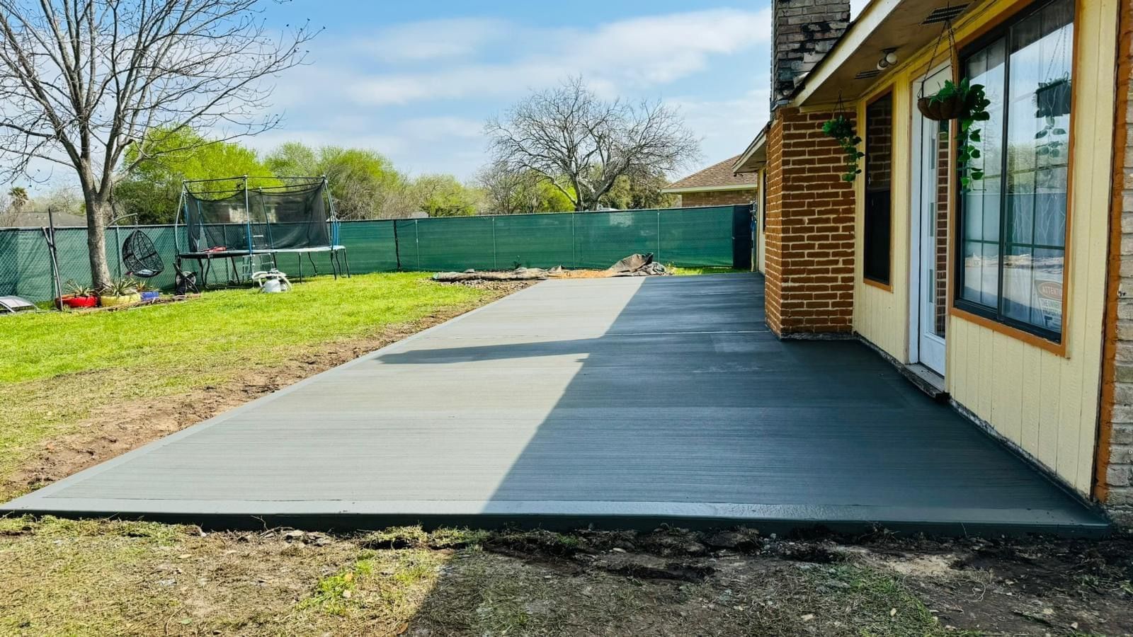 A concrete patio is being built in front of a house.