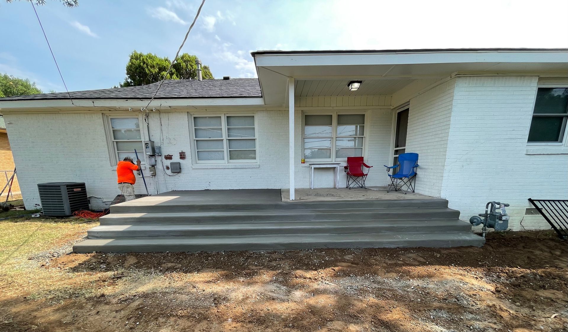 A white house with a concrete porch and stairs