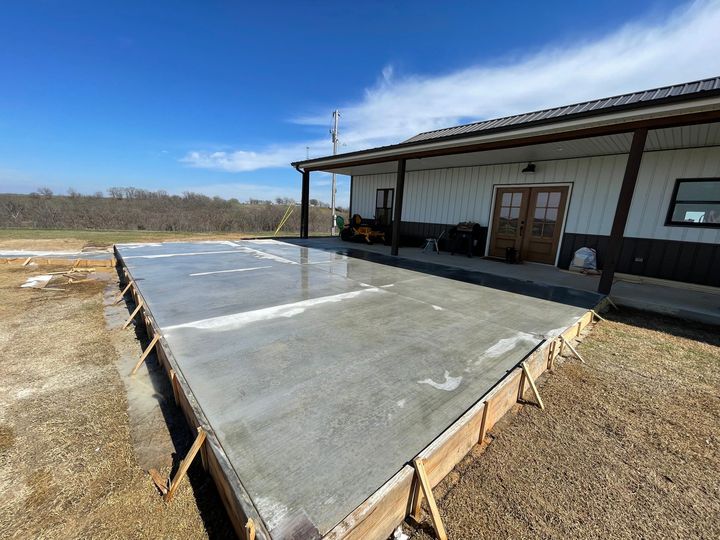 A large concrete slab is being built in front of a house.