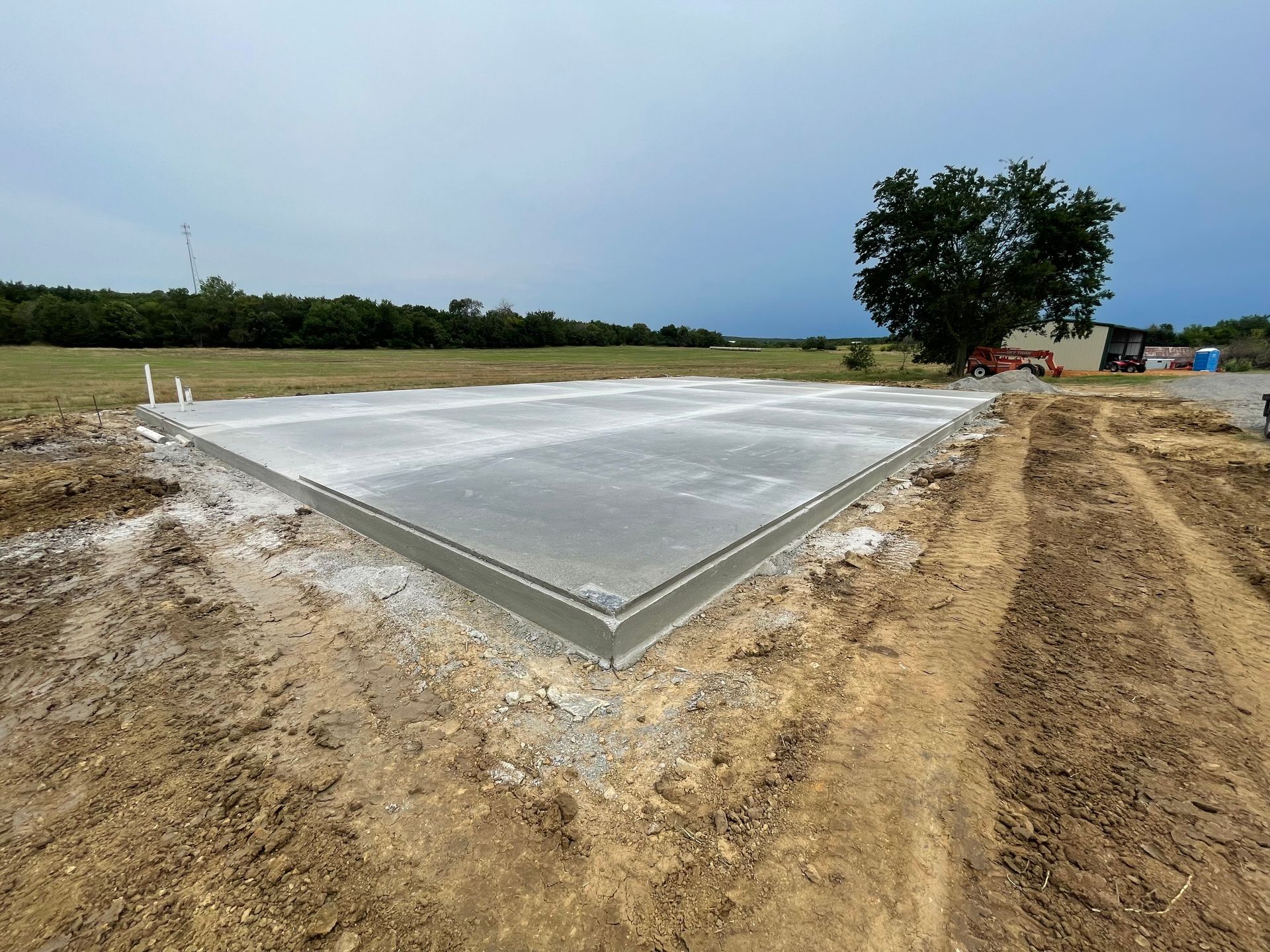 A concrete foundation is being built in a field