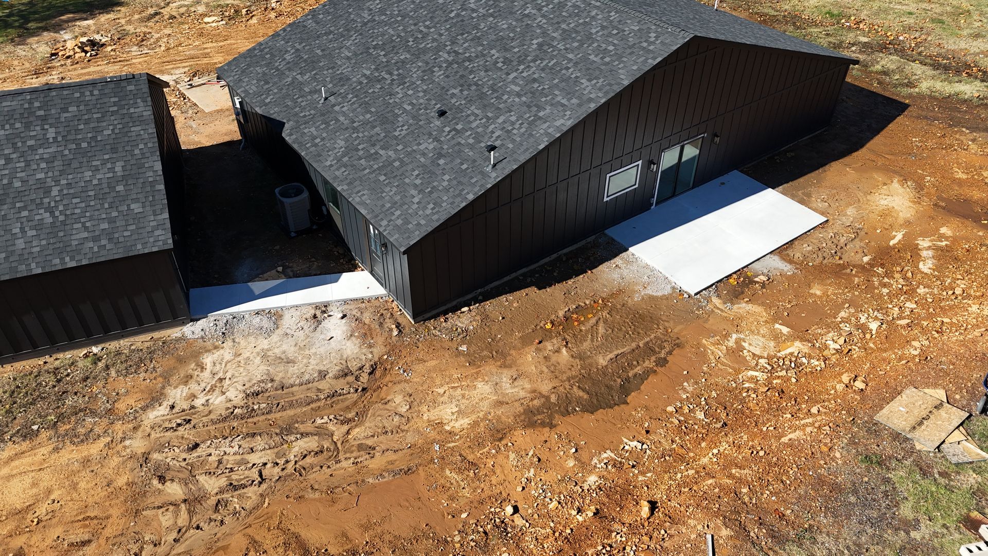 An aerial view of a house sitting on top of a dirt field.