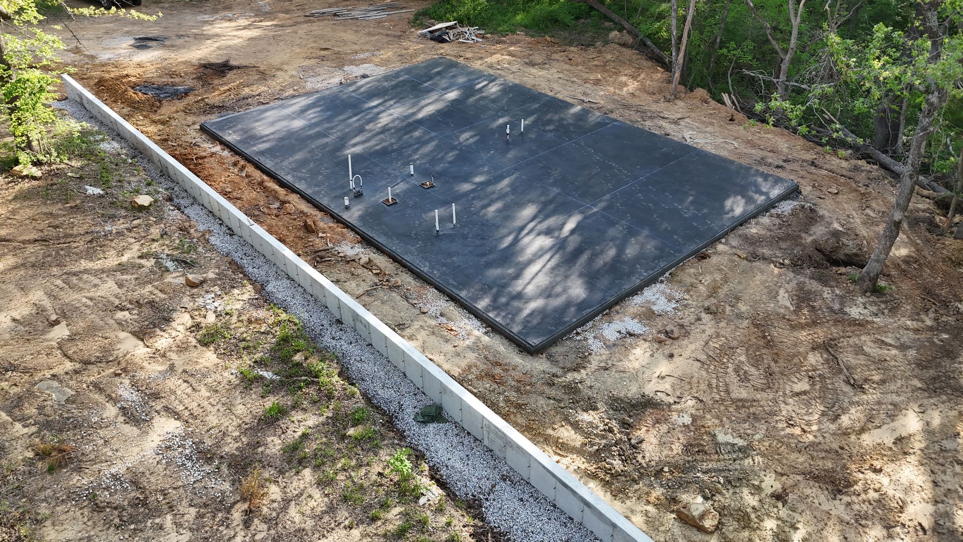 A large concrete slab is sitting on top of a dirt field.