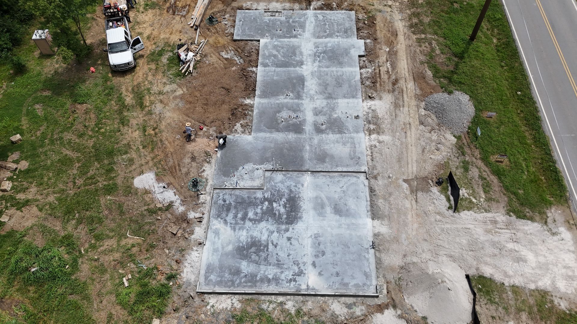 A large concrete slab is sitting in the middle of a dirt field.
