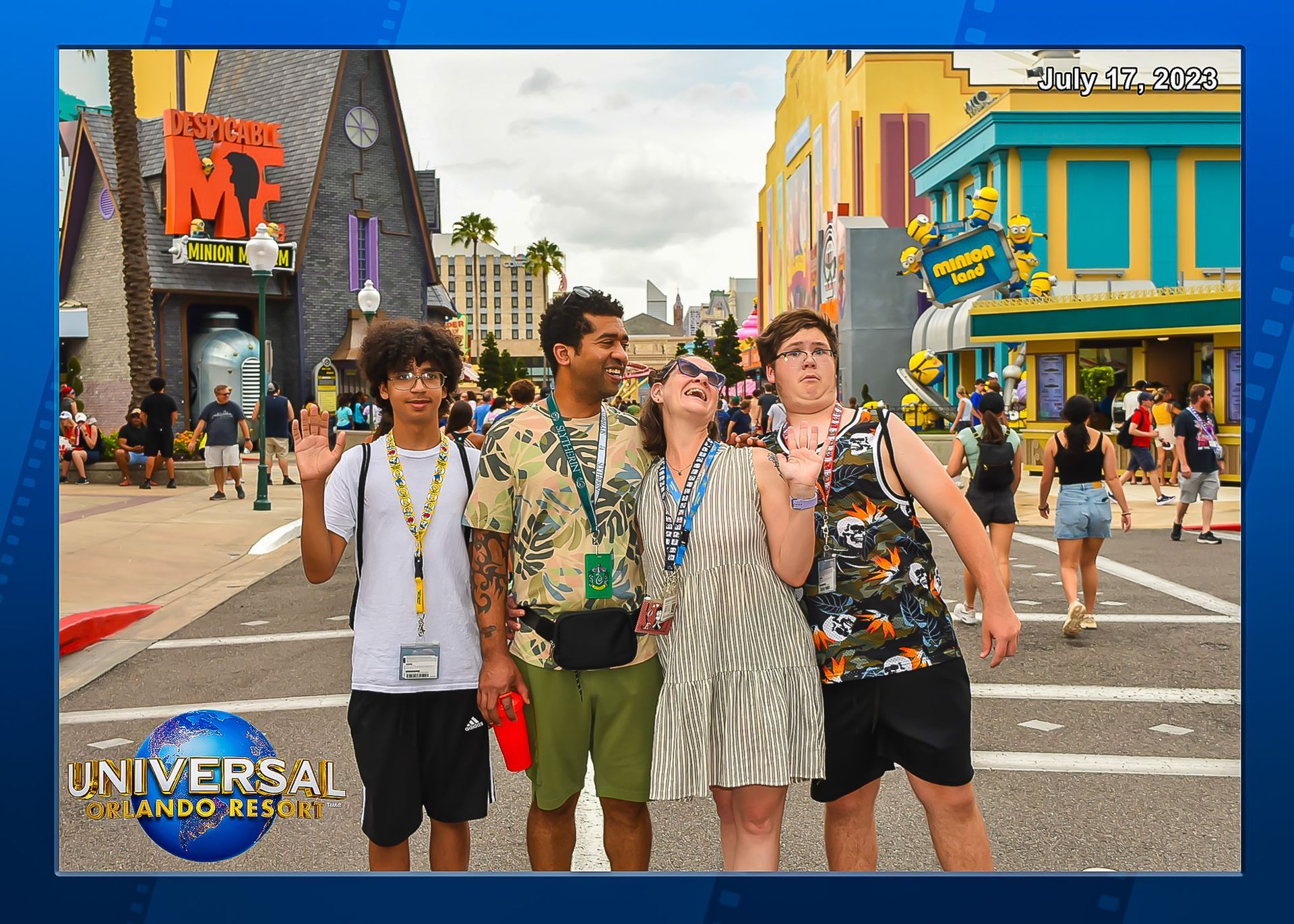 Group of five smiling at Universal Studios, posing in front of Minions ride, sunny day.